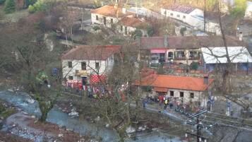 A rural village with traditional buildings, a river, and a small gathering of people.
