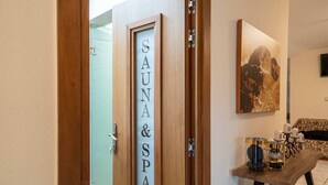 Una puerta con la inscripción "SAUNA & SPA", con marco de madera, puerta de cristal y un cuadro colgado en la pared.
