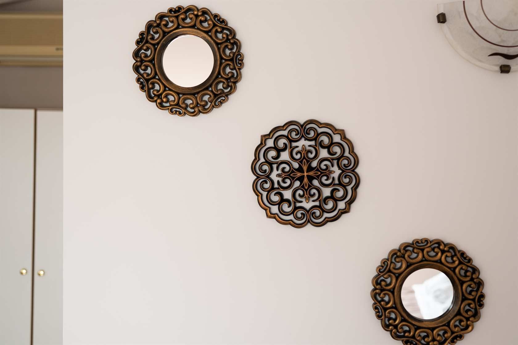 Three ornate wall mirrors of different sizes.