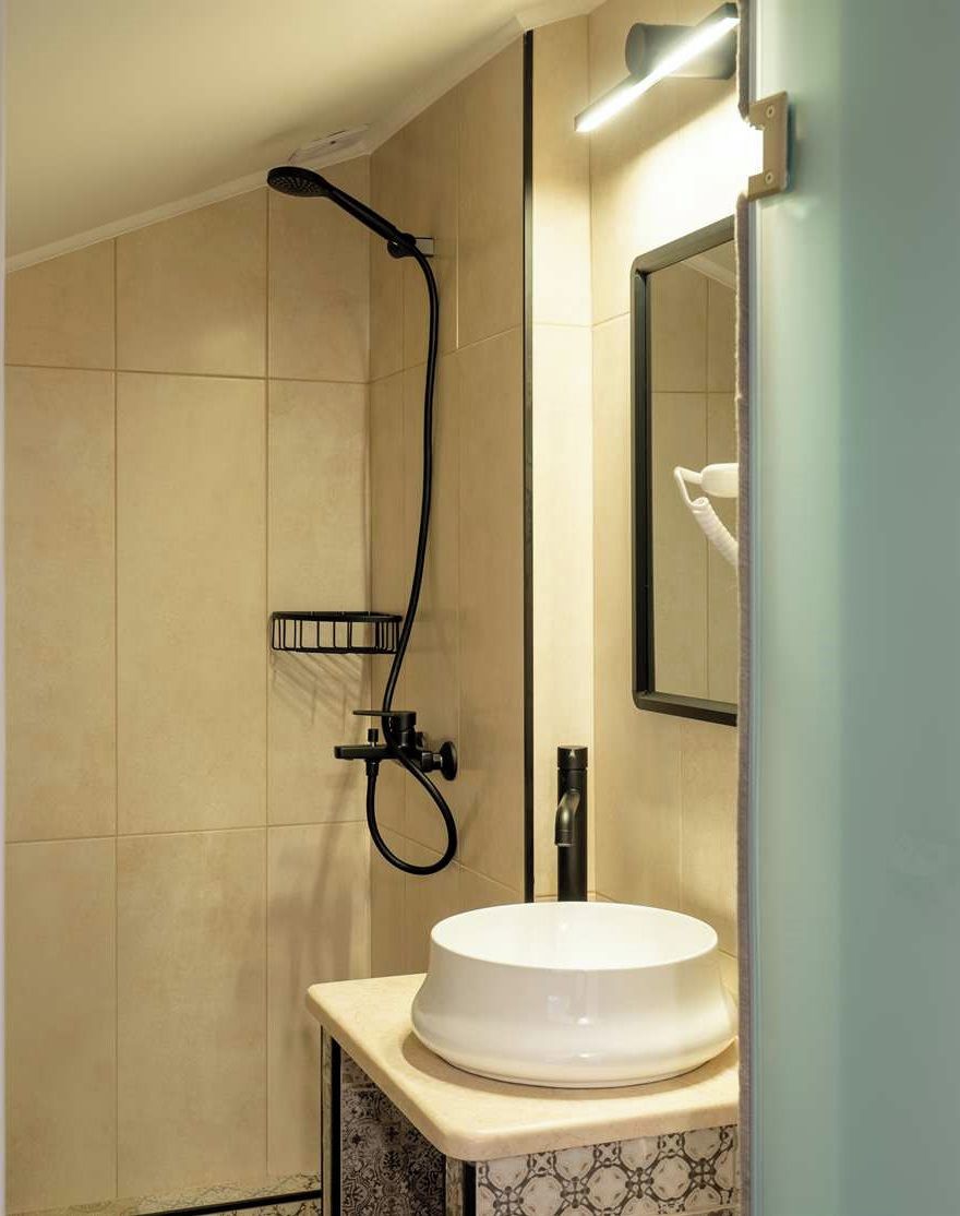 A modern bathroom with a shower, a sink, and a mirror.