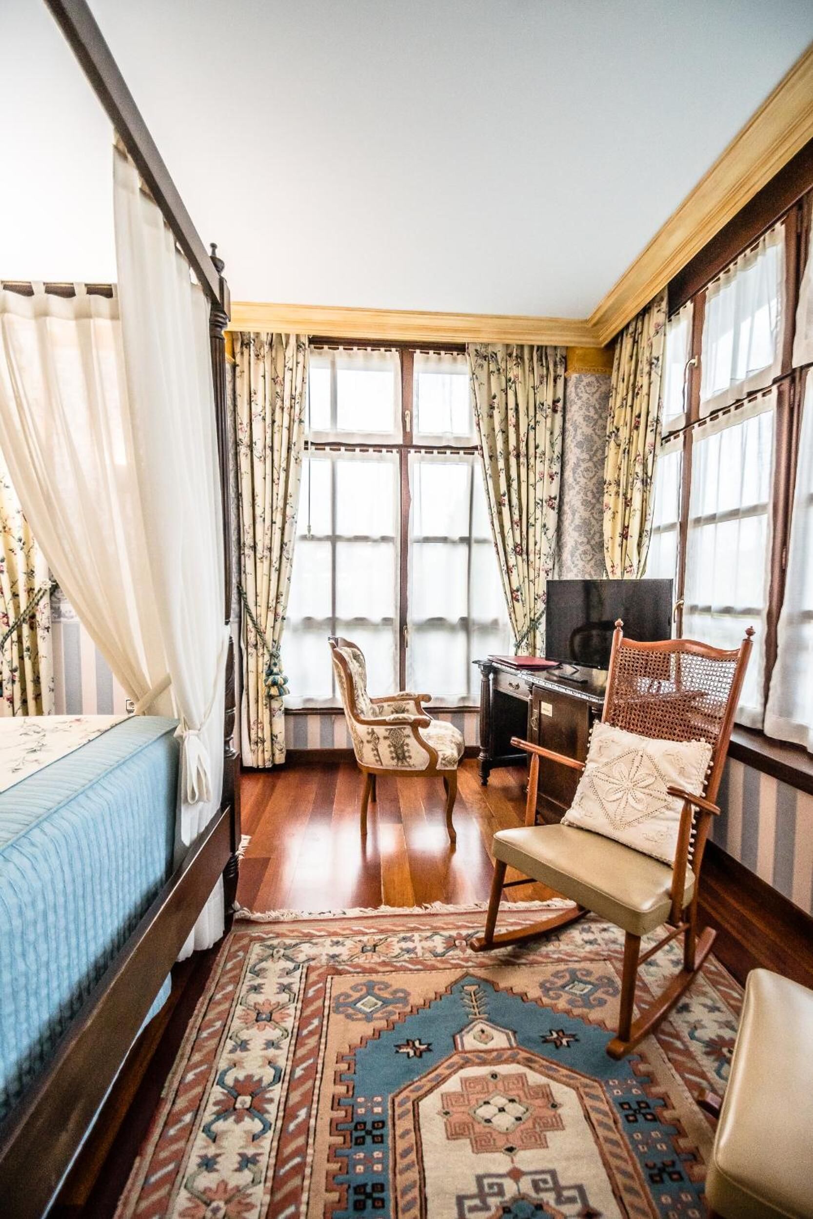 A room with a bed, a desk, a chair, and a television.