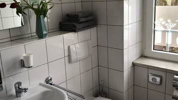 A modern bathroom with a white sink, toilet, and vanity.