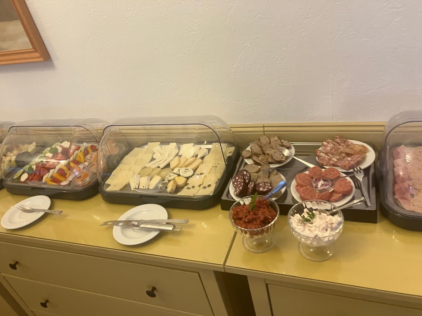 Una mesa de buffet con diversos alimentos y utensilios.