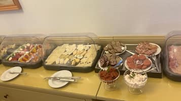 A buffet table with various food items and utensils.