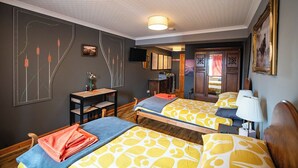 Una habitación de hotel con dos camas, un escritorio, una silla, un televisor y un armario.