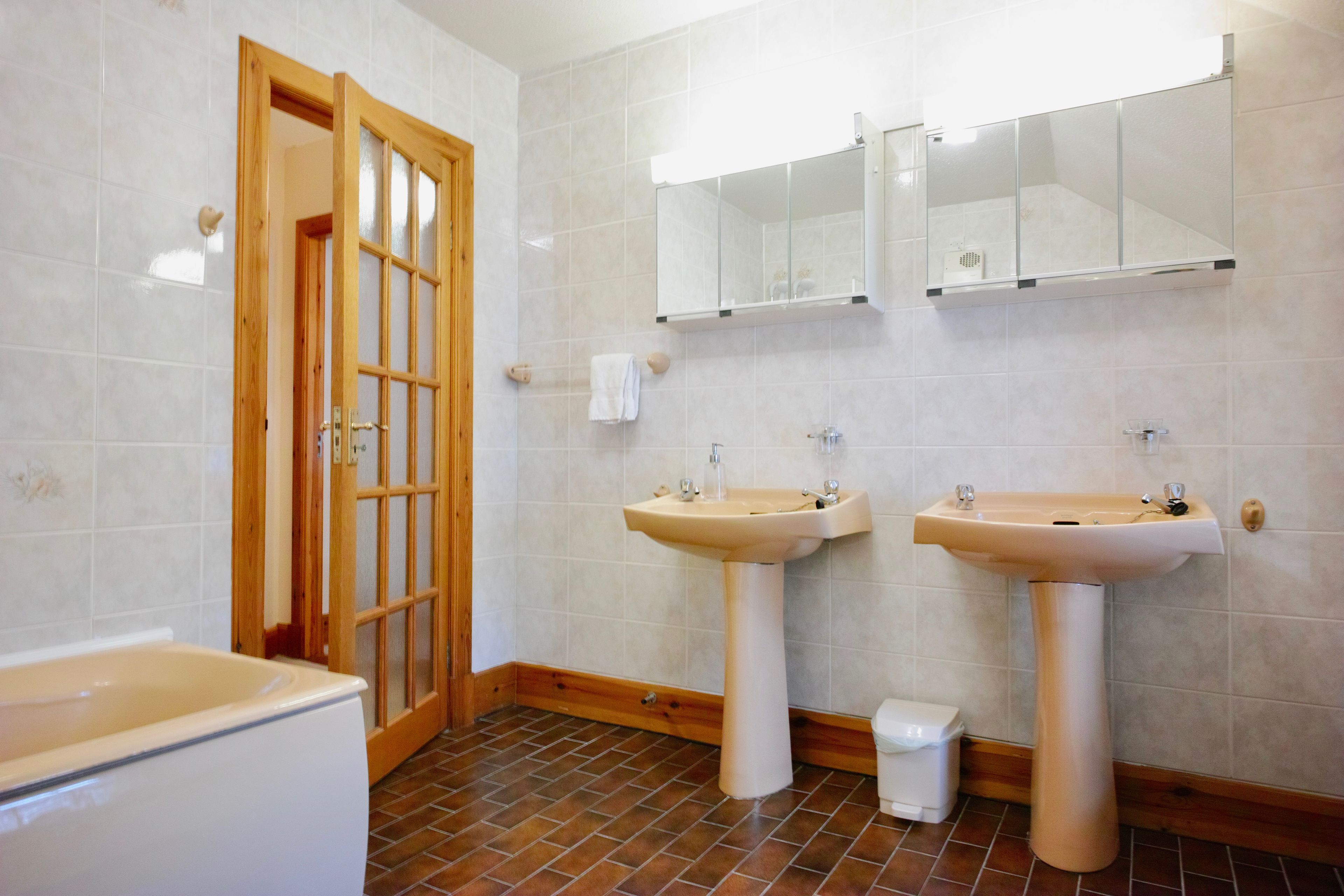 A bathroom with two sinks, a mirror, and a shower.