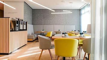 Ein modernes Restaurant mit Empfangstresen, Sitzgelegenheiten und Wandverkleidung mit Muster.
