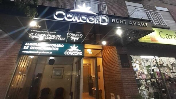 A building with a 'Concord Rent Apart' sign, indicating it is a rental property. There is a visible entrance with steps leading up to it. - Concord Rent Apart (Córdoba)
