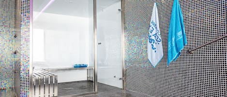 Una habitación moderna con puerta de vidrio, paredes de malla metálica y suelo estampado.