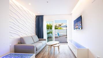 Una sala de estar moderna con un sofá, una mesa de centro, una mesa con cubierta de vidrio y un acuario integrado.