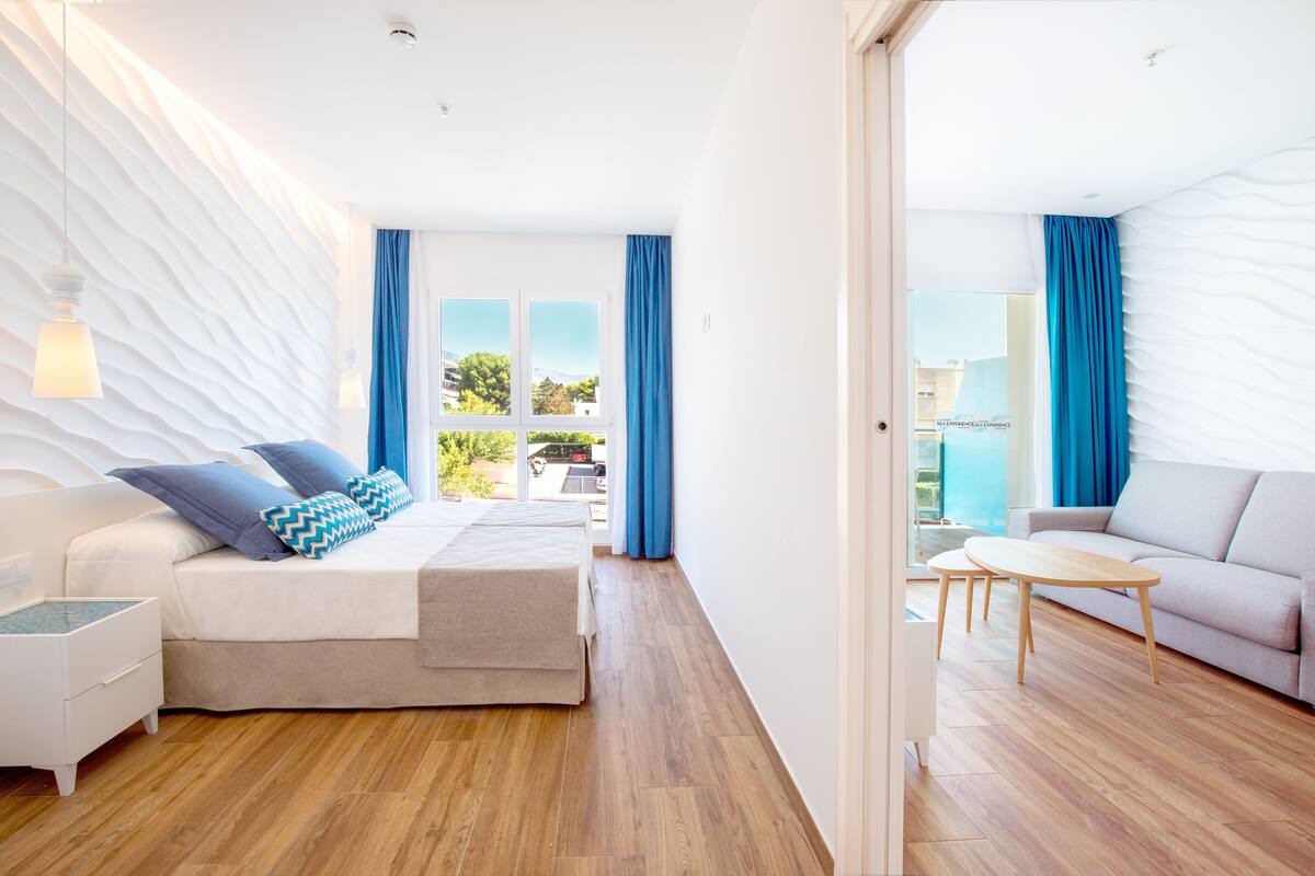 Un dormitorio moderno con cama, mesita de noche y vistas al exterior.