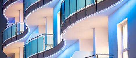 A modern building with curved balconies and glass railings.