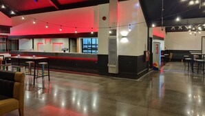 A spacious indoor area with a counter, seating, and tables.