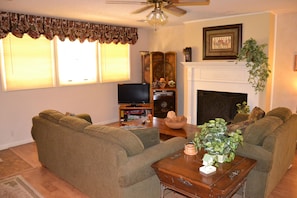 Relax in this traditional living room with a sofa, coffee table, and fireplace.