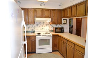 Enjoy cooking in this well-equipped kitchen with a stove, microwave, and ample counter space.