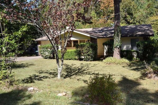 Set amidst mature trees and shrubs, this single-story house offers a serene atmosphere.