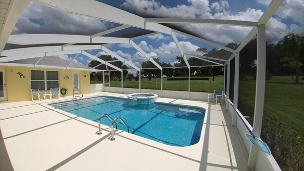 A covered outdoor swimming pool with a view of the surrounding landscape. - Villa Lovie - Comfort - 4 Bedroom (Inverness)