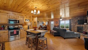 Interior de una cabaña de madera con cocina, comedor y sala de estar.