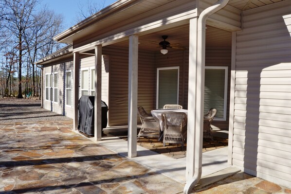 Relax in the covered outdoor seating area with a wicker table and chairs.