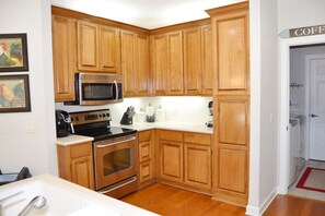 Kitchen area with modern appliances, microwave, toaster, and oven.