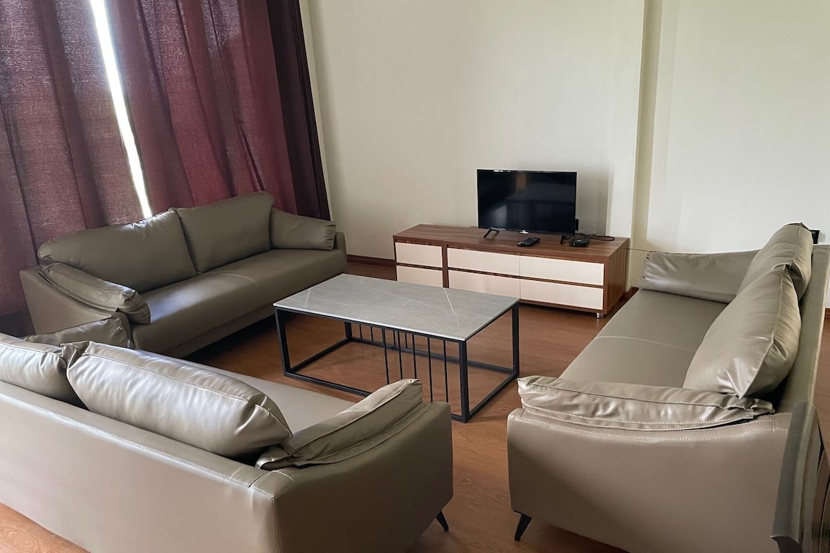 A living room with a sofa, a coffee table, and a TV stand.