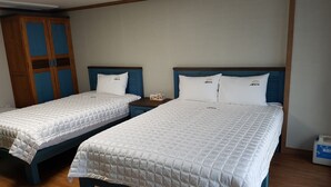 Two single beds with wooden frames and blue headboards in a room with wooden flooring and a wardrobe with blue doors. - The View Hostel (Tongyeong)