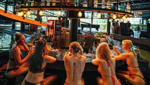 Un bar de varios niveles con una fuente central, rodeado de zonas de estar.