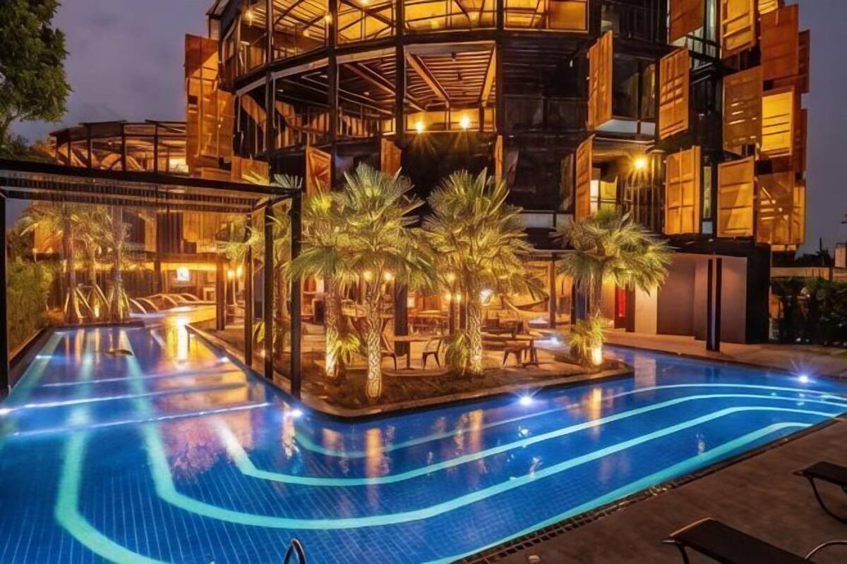 Una piscina con una estructura arquitectónica moderna al fondo.