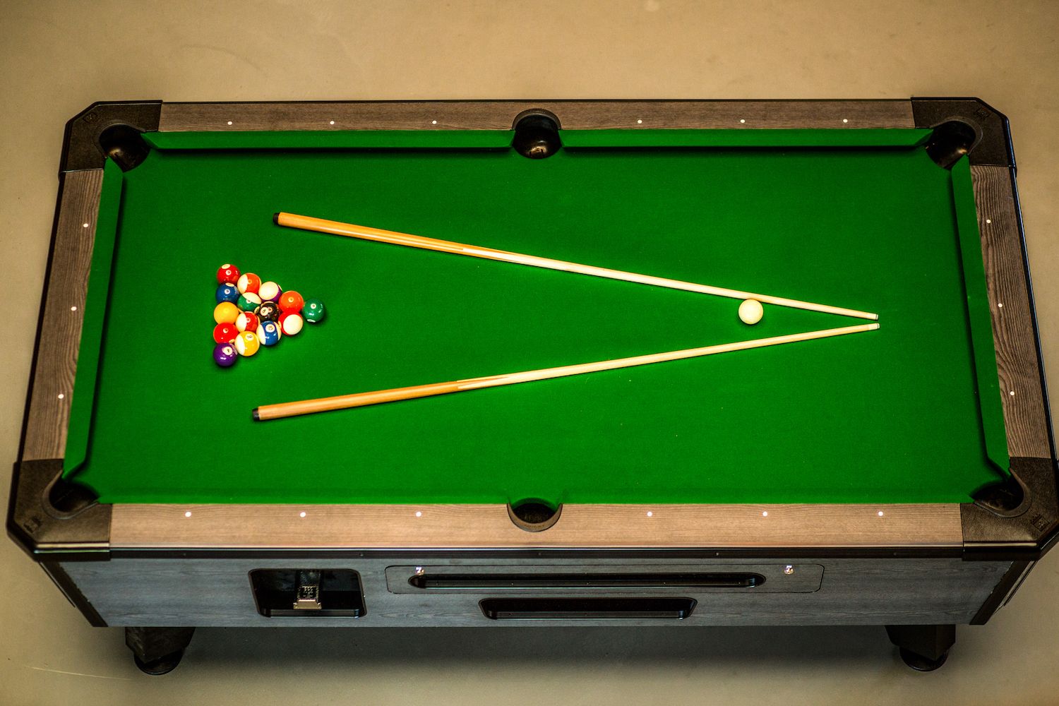 Une table de billard avec des billes et des queues.