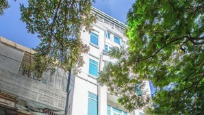 Un immeuble portant une enseigne indiquant « A25 Hotel » et « Domov Luxury Hotel ».
