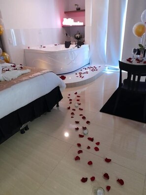 A hotel room with a bed, a bathtub, and a small table with balloons. - Hotel San Antonio Guarne (Guarne)