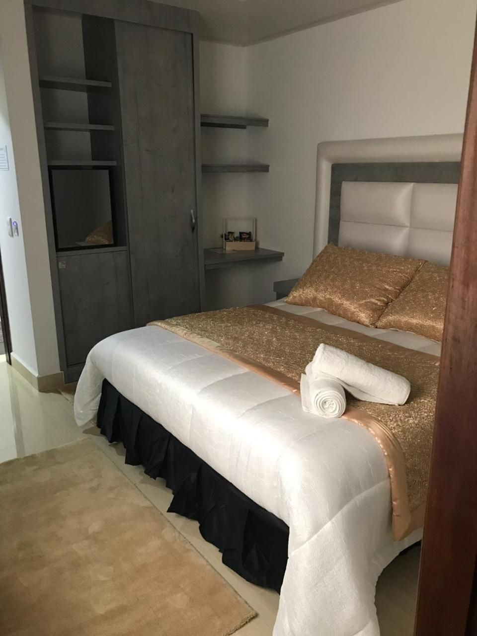 Une chambre à coucher avec un lit, une armoire et une table de chevet.