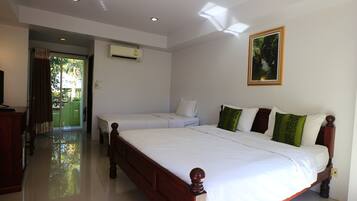 A bedroom with a large bed, a smaller bed, a dresser, and a painting on the wall.