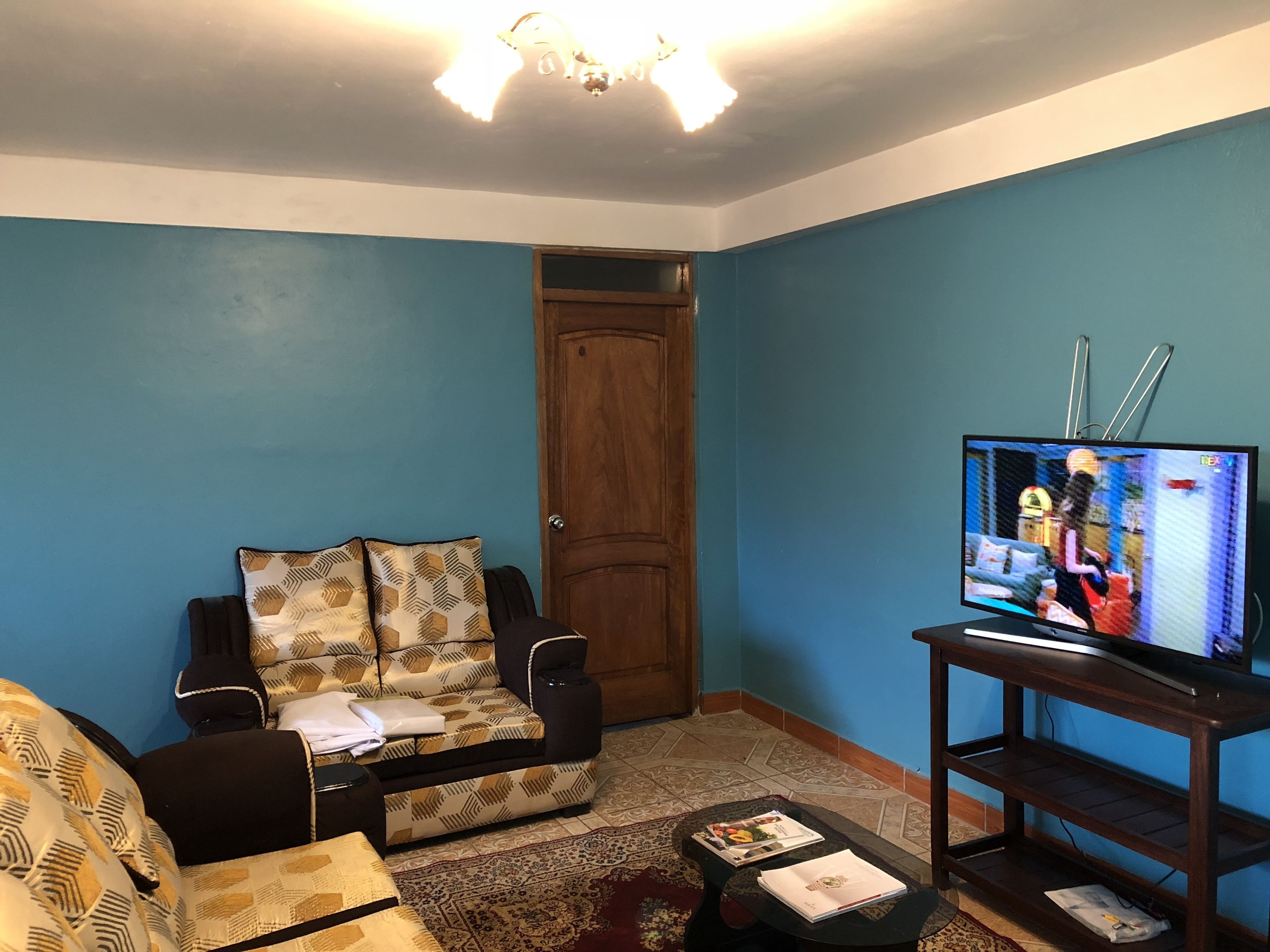 Un salon avec un canapé, une table basse et un téléviseur posé sur un meuble.
