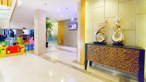 A modern lobby with a children's play area, a reception desk, and a television screen. - Shanghai Pudong Airport Yueshangju Hotel (Shanghai)