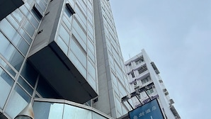 Um edifício de hotel moderno com uma placa azul chamativa que diz "HOTEL".