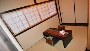 A traditional Japanese room with tatami flooring, a low table with a cushion, and a shoji screen. - Kumoi Kiyomizu (Kyoto)