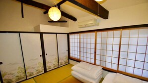 A traditional Japanese room with tatami flooring, shoji screens, and a hanging paper lantern. - Kumoi Jurakumawari (Kyoto)