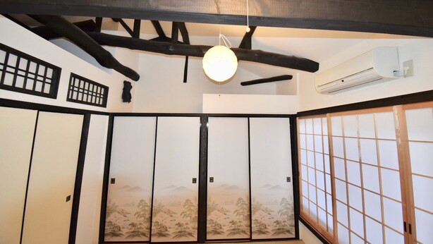 A traditional Japanese room with tatami flooring, shoji screens, and a ceiling fan. - Kumoi Jurakumawari (Kyoto)