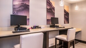 A modern workspace with two monitors, a keyboard, and two white chairs.