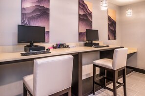 Un espace de travail moderne équipé de deux écrans, d’un clavier et de deux chaises blanches.