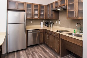 A modern kitchen with stainless steel appliances, wooden cabinets, and a built-in dishwasher. - Staybridge Suites Pecos by IHG (Pecos)