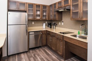 Una cocina moderna con electrodomésticos de acero inoxidable, armarios de madera y lavavajillas integrado.
