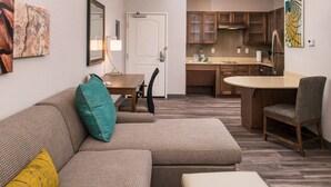 A modern apartment with a living room, dining area, and kitchen.