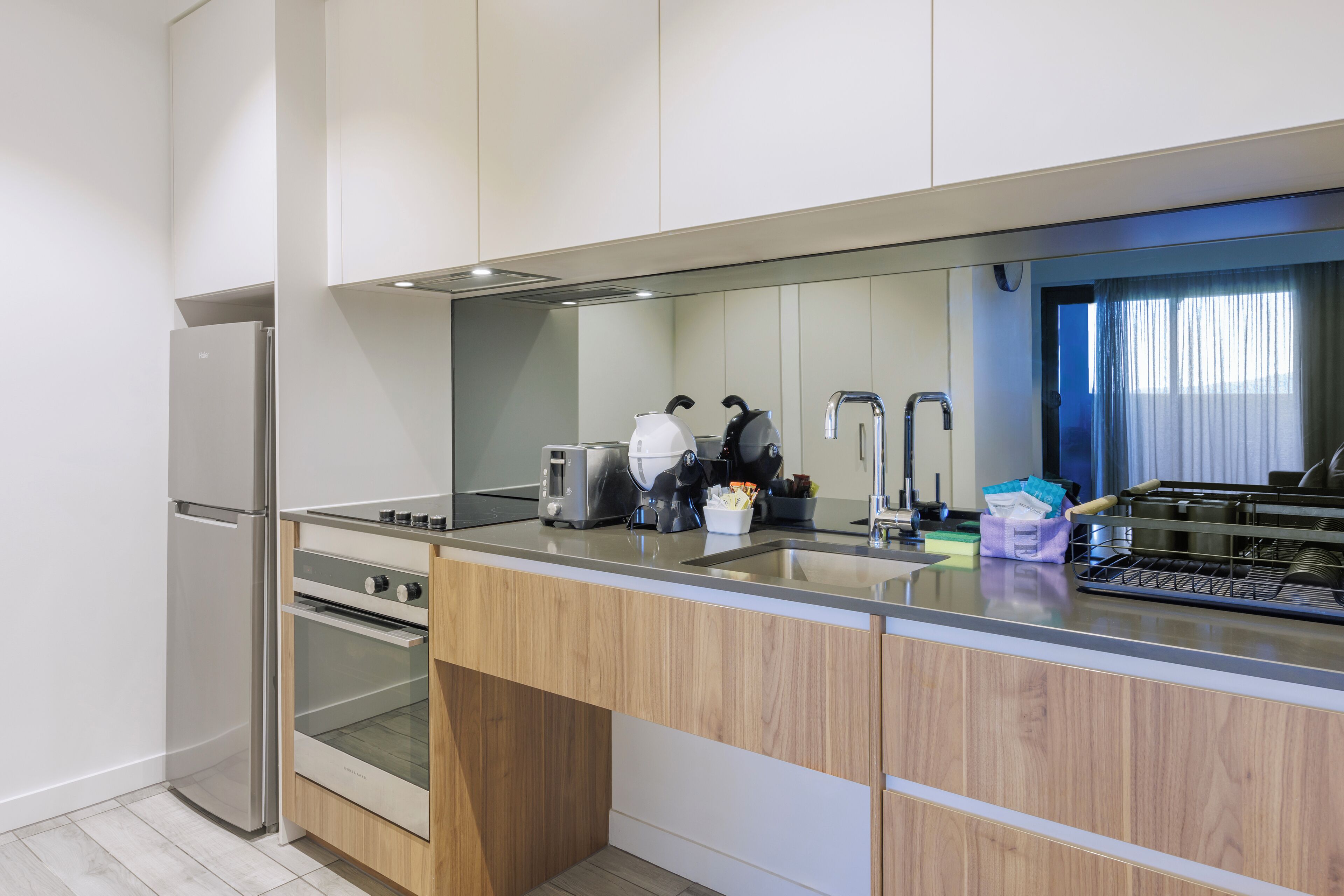 A modern kitchen with stainless steel appliances, a wooden countertop, and a built-in oven.
