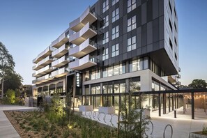 Un hotel moderno con un diseño arquitectónico único, con varios balcones y ventanas amplias.