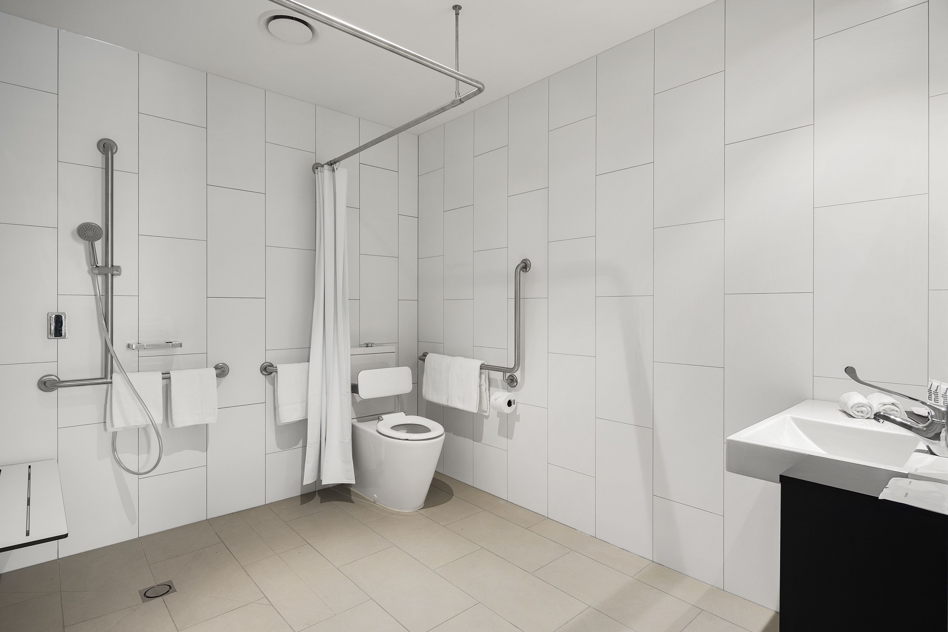 Une salle de bain moderne équipée d’une douche, de toilettes et d’un lavabo.