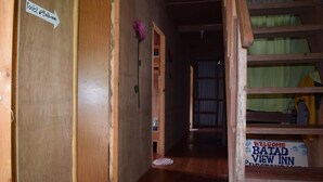 A wooden hallway with a sign indicating the direction to the toilet and bathroom. There is a welcome sign for Batad View Inn. - Batad View Inn and Restaurant (Banaue)