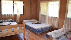A wooden cabin room with two beds, a wooden bench, and large windows with sheer curtains. - Batad View Inn and Restaurant (Banaue)