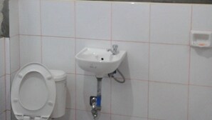 A bathroom with a toilet, sink, and shower. - Batad View Inn and Restaurant (Banaue)